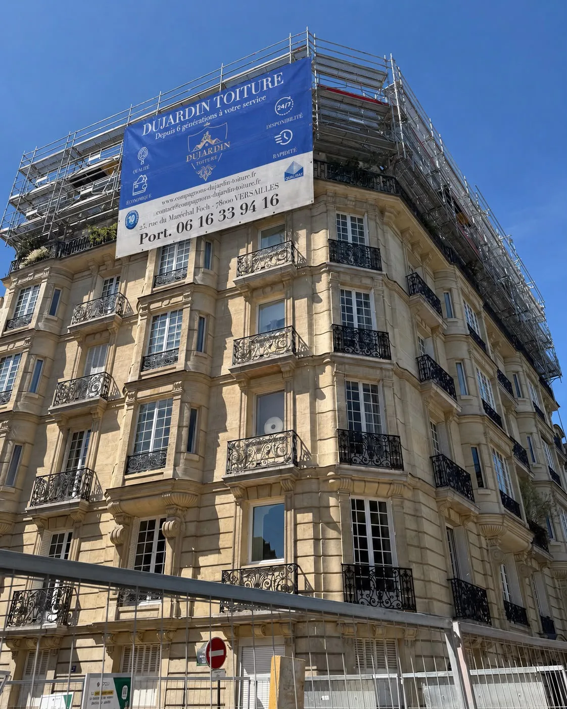 Chantier Dujardin Toiture sur immeuble haussmannien, bâche de chantier aux couleurs de l'entreprise